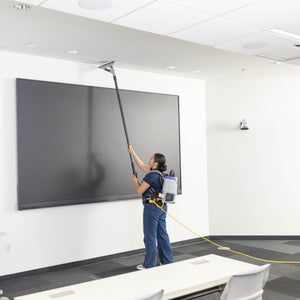 Cleaning the top of a wall display with the GoHigh ProBlade from the floor
